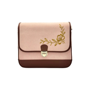 A rectangular flap shoulder bag by needlesay collection called botanica blush in blush pink denim and dark brown genuine leather, featuring a gold floral vine design on the front flap and a gold-tone metal clasp.
