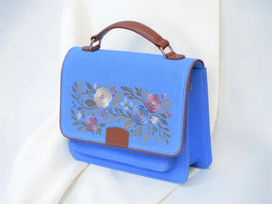 Azure Blue denim handbag with floral embroidery on a white background by needlesay
