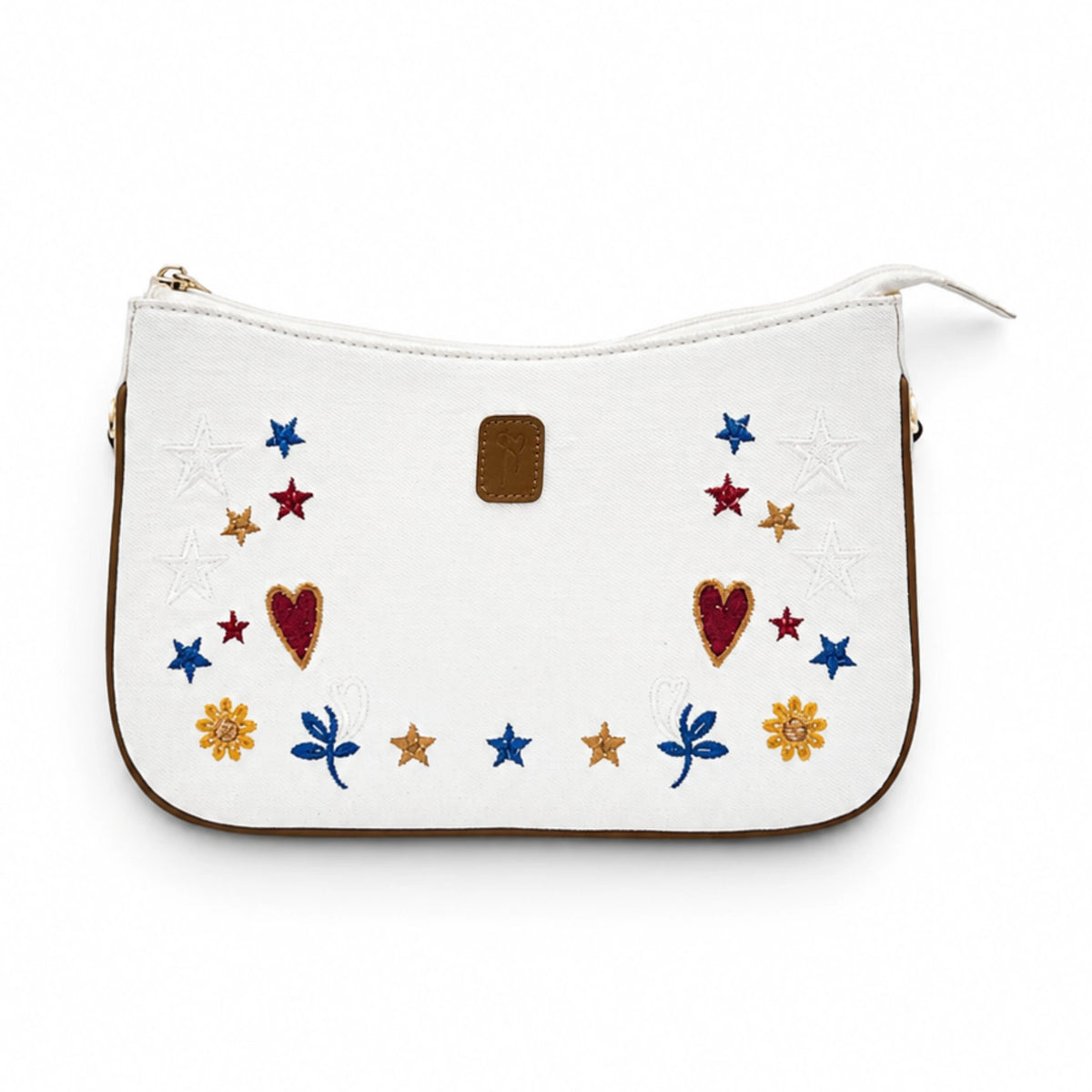 Needlesay white denim shoulder bag with colorful embroidered stars, hearts, flowers, blue leaf motifs, brown leather trim, and gold-tone hardware.