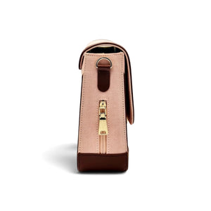A structured shoulder bag by needlesay shown from the side, featuring a light pink denim body with dark brown genuine leather trim and a gold-tone zipper pull.