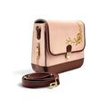 Needlesay structured rectangular shoulder bag in blush pink denim and dark brown genuine leather with gold floral embroidery on the front flap and gold-tone hardware, shown with a detachable brown shoulder strap on a white background. the collection name is botanica 