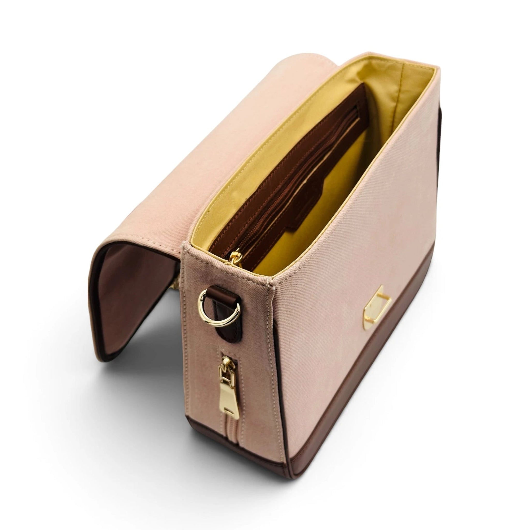 A blush pink and brown denim and leather clutch bag of needlesay botanica blush with a gold-tone zipper and ring, shown open to reveal a yellow interior lining, on a white background.