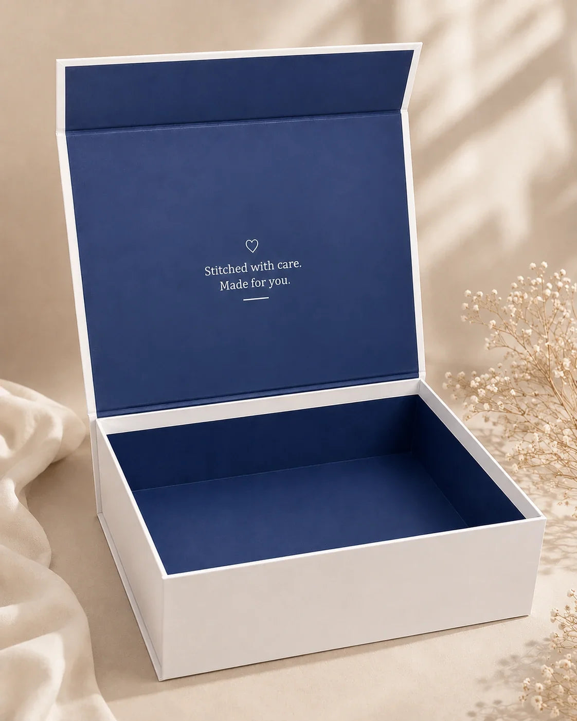 Needlesay signature gift box open, showing navy interior with Stitched with care message