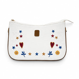 Needlesay white denim shoulder bag with colorful embroidered stars, hearts, flowers, blue leaf motifs, brown leather trim, and gold-tone hardware.